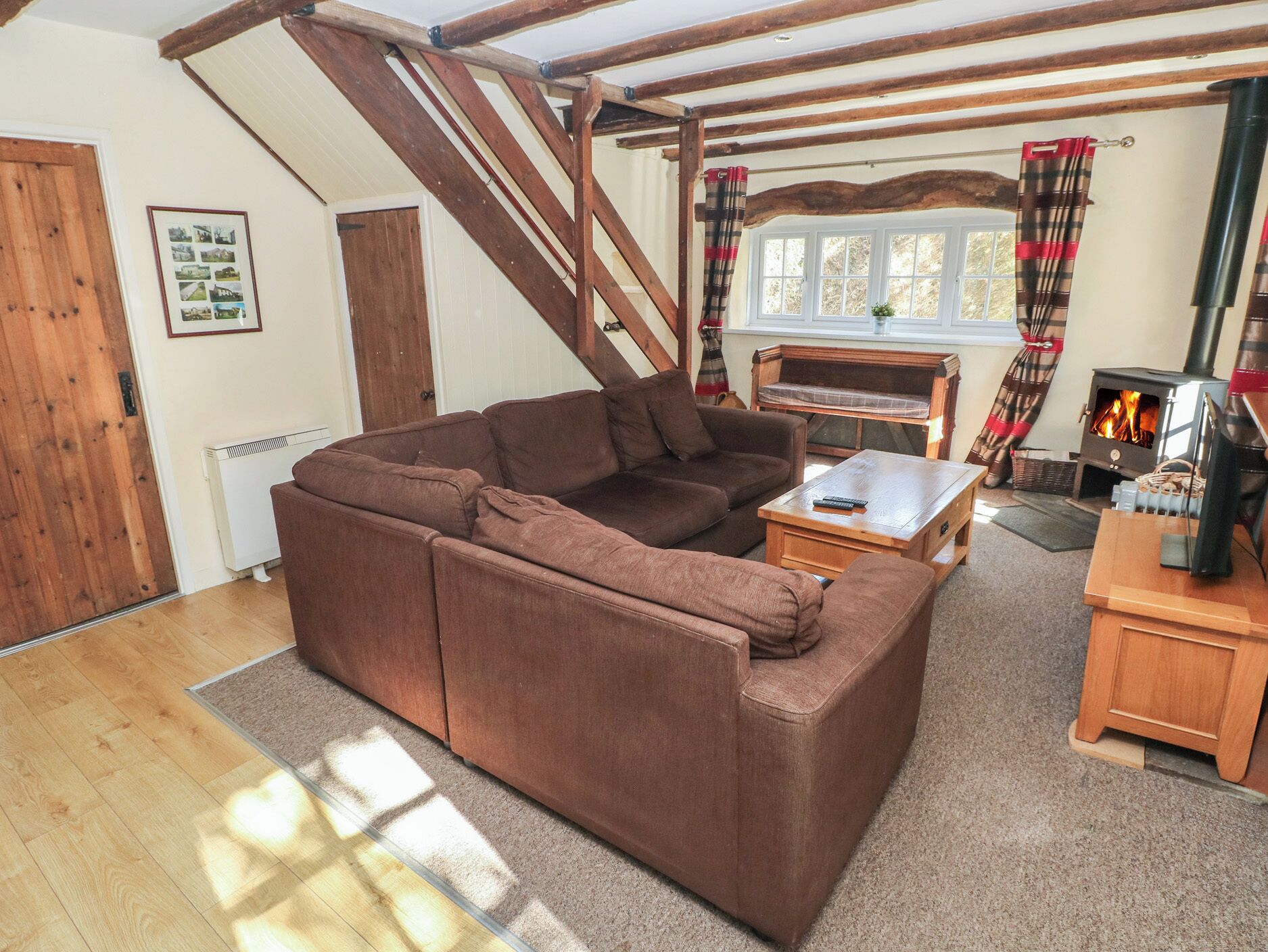 Un salon chaleureux avec un canapé marron, une table basse en bois et une cheminée.