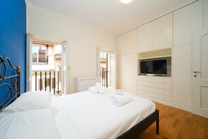 A bedroom with a bed, a TV, and a wardrobe.