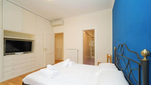 Una camera da letto con un letto, una televisione e un armadio.