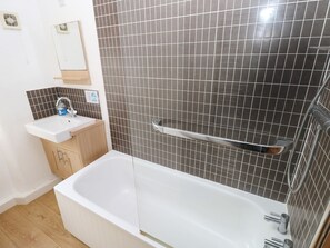 Ein Badezimmer mit Badewanne, Waschbecken und Spiegel.