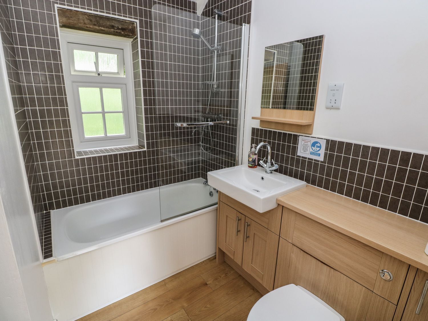 Ein Badezimmer mit einer Badewanne, einem Waschbecken und Holzschränken.