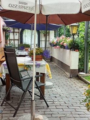 Een terras met een tafel, stoelen en parasols.
