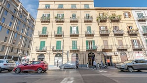 A multi-story building with balconies, a storefront, and a pedestrian crossing. - Turati Apartment al Politeama by Wonderful Italy (Palermo)