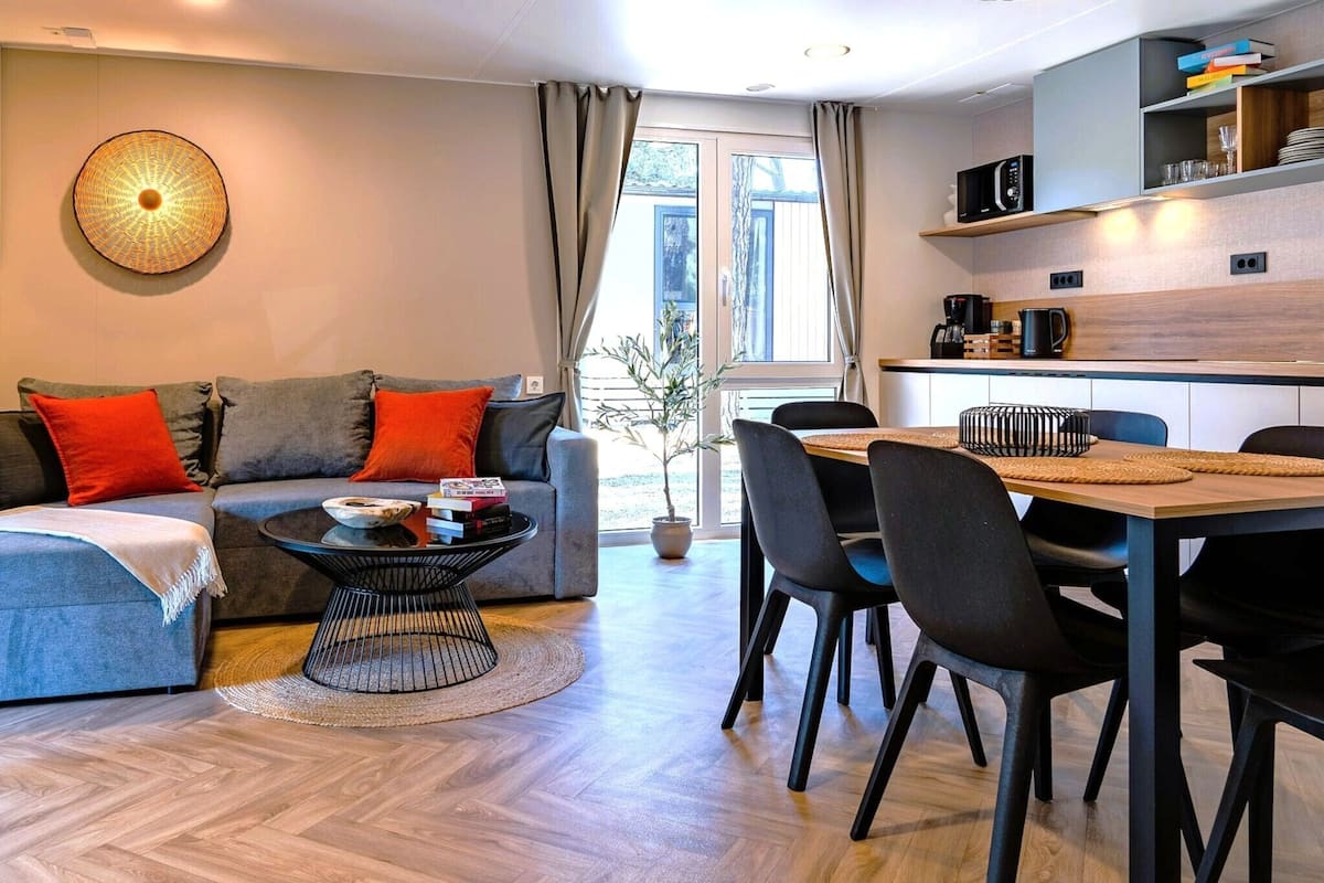 Ein modernes Wohnzimmer mit Sofa, Couchtisch und Essbereich.