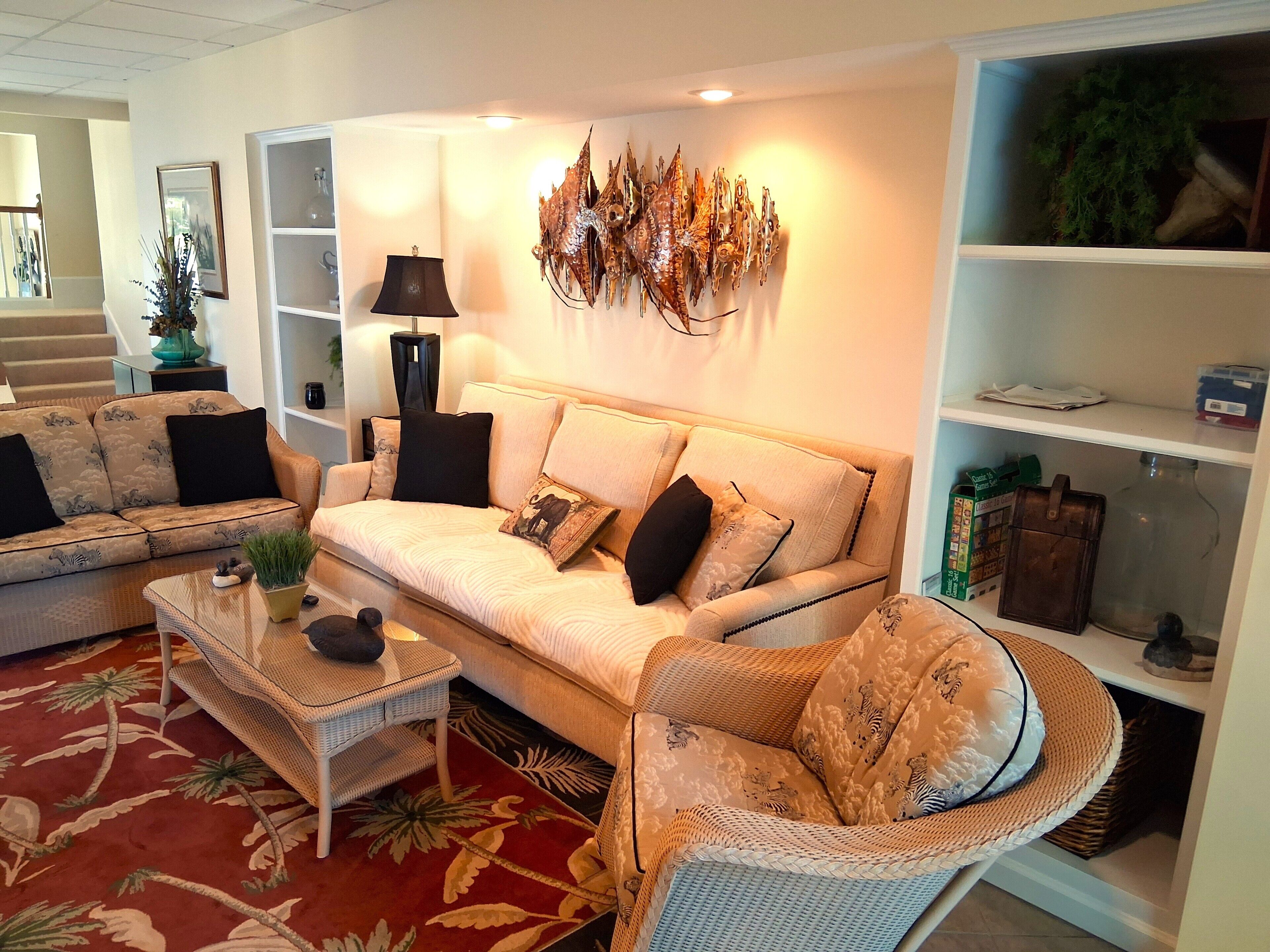A living room with a sofa, two armchairs, a coffee table, and a bookshelf.