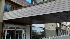 A modern building with a flat roof, large windows, and a covered entrance area. - Entire condo in San Carlos de Bariloche, Argentina (San Carlos de Bariloche)
