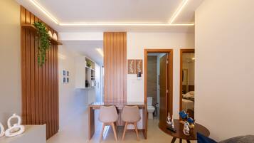 Ein modernes Interieur mit Essbereich, Holzakzenten und Blick in ein Schlafzimmer.