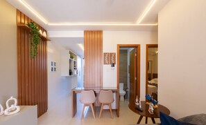 Un intérieur moderne avec un coin repas, des éléments décoratifs en bois et une vue sur une chambre.