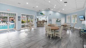 A spacious indoor area with a pool, dining area, and kitchen. - Oceanwalk 11-603 (New Smyrna Beach)