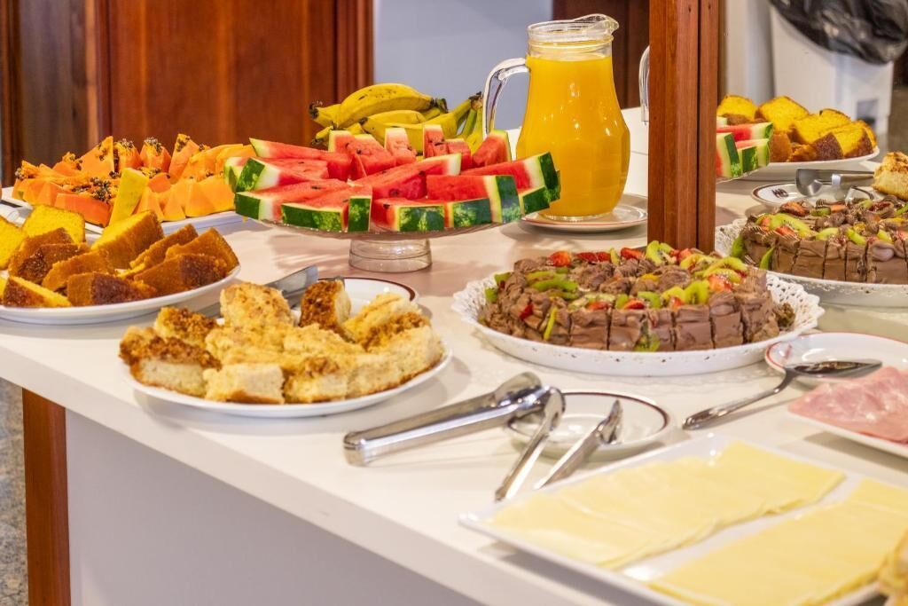 A buffet with various dishes including fruits, bread, and a chocolate dessert.