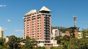 A multi-story hotel with a flat roof and a prominent corner tower. - Goldmen Business Hotel Blumenau (Blumenau)