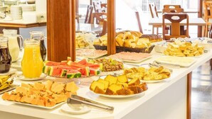 A buffet with various food items and beverages. - Goldmen Business Hotel Blumenau (Blumenau)