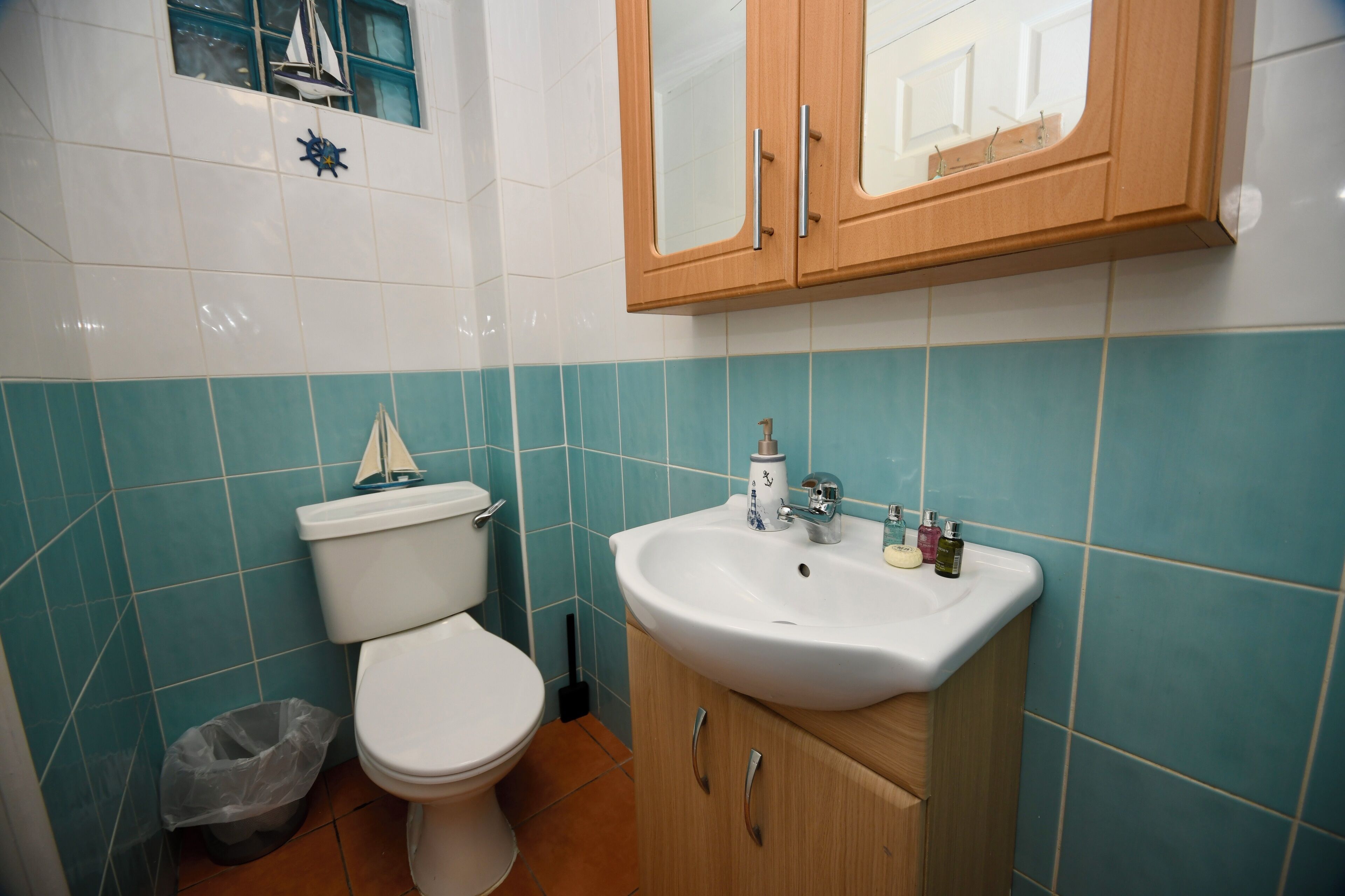 Une salle de bain avec des toilettes, un lavabo et un meuble de rangement.