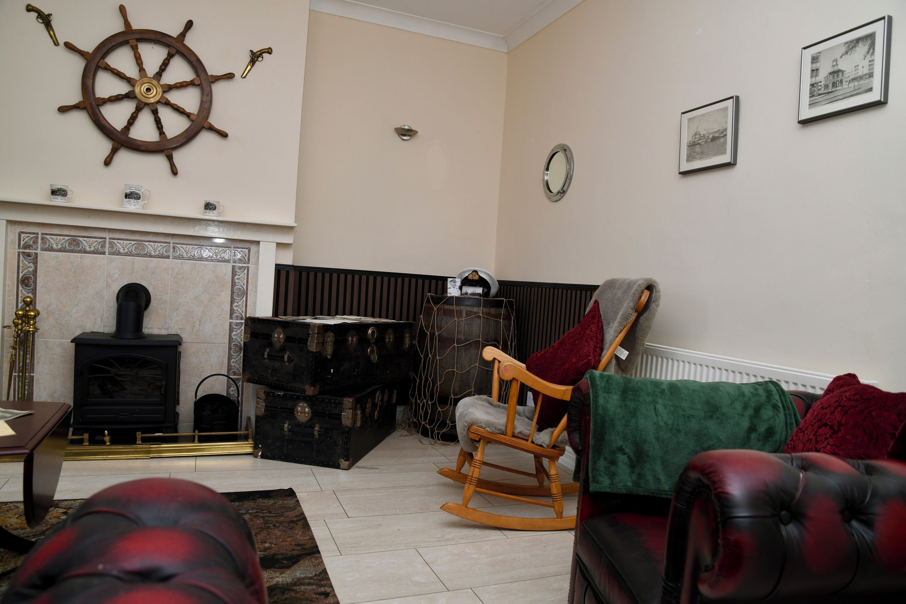 A living room with a fireplace, a rocking chair, and a leather sofa.