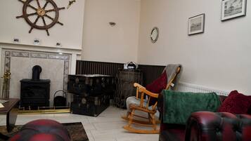 A living room with a fireplace, a rocking chair, and a leather sofa.