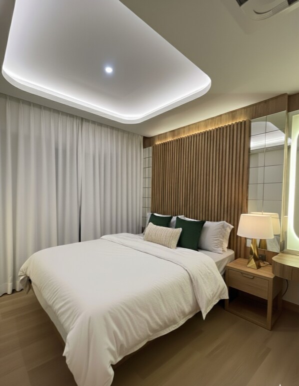 Een moderne slaapkamer met een groot bed, een nachtkastje met lamp en een plafondlamp.