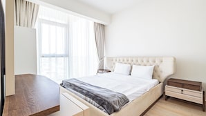 A modern bedroom with a large bed, bedside tables, a desk, and a window with curtains. - Superhost  Stylish 1BR in Bloom Tower (Dubai)