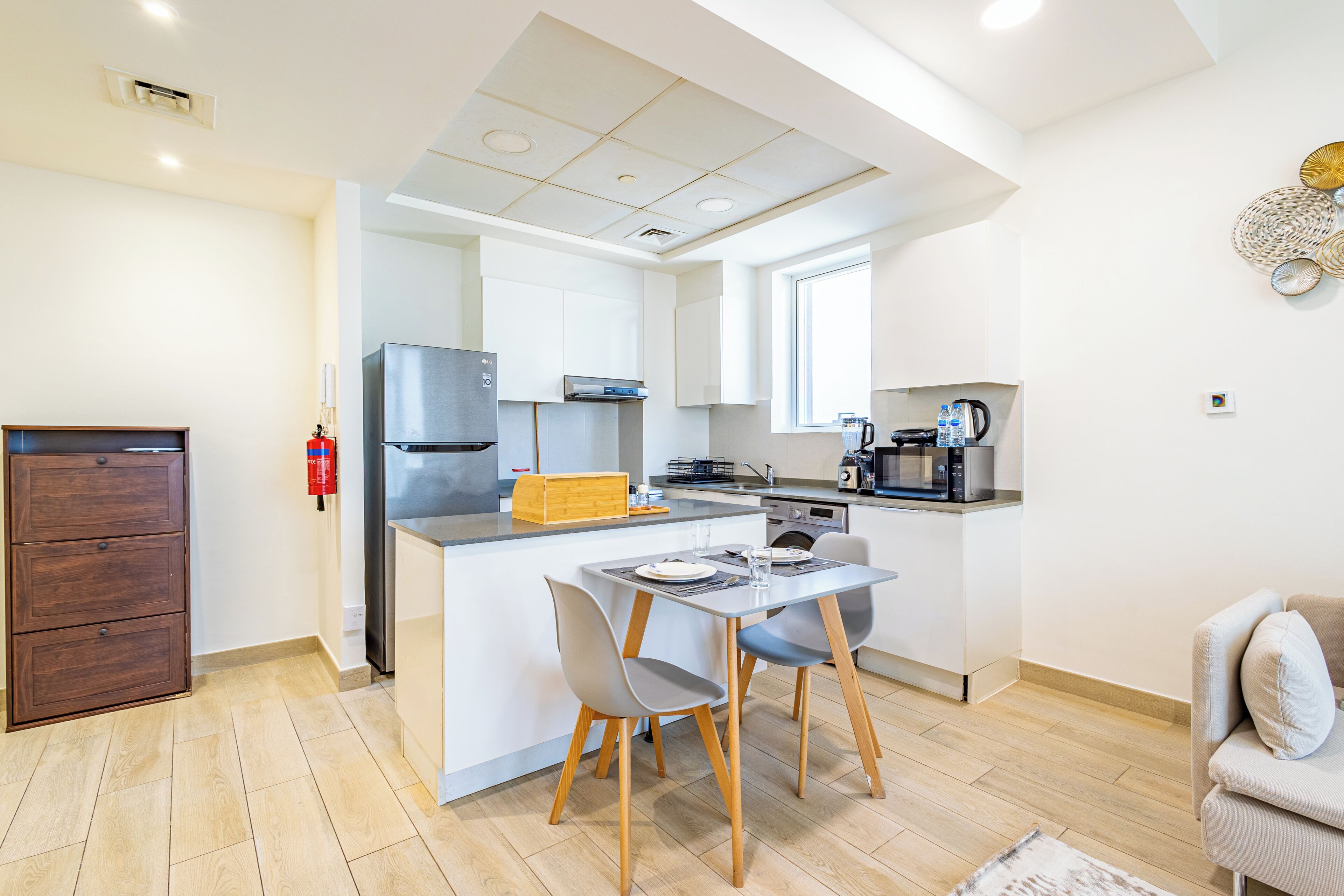Une cuisine moderne dotée d’un îlot central, de meubles en bois et d’un coin repas avec deux chaises.