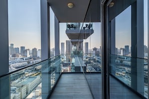 A high-rise building with a glass balcony offering a city view. - Superhost Stylish 1BR in Bloom Tower (Dubai)