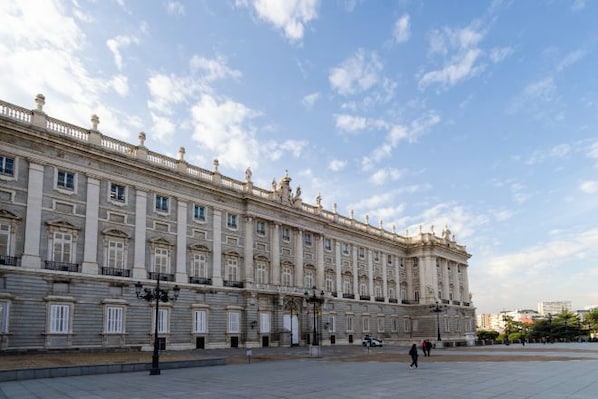 Un edificio grande e histórico con fachada simétrica, múltiples ventanas y una entrada central.