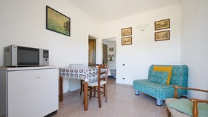 A compact living space with a kitchenette, dining table, and seating area. - Room 'Camera 3 - Campo Ruffaldo' with Shared Pool, Wi-Fi and Air Conditioning (Massa Marittima)