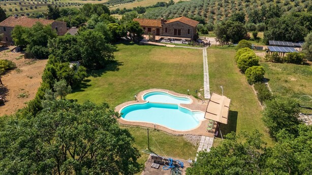 A house with a swimming pool, surrounded by a large grassy area and trees. - Room 'Camera 3 - Campo Ruffaldo' with Shared Pool, Wi-Fi and Air Conditioning (Massa Marittima)