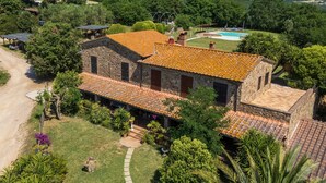 A stone building with a tiled roof, surrounded by greenery and a swimming pool. - Room 'Camera 4 - Campo Ruffaldo' with Shared Pool, Wi-Fi and Air Conditioning (Massa Marittima)