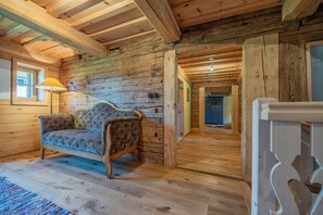 Ein rustikales Blockhaus-Interieur mit einer Couch, Holzböden und einer Lampe.