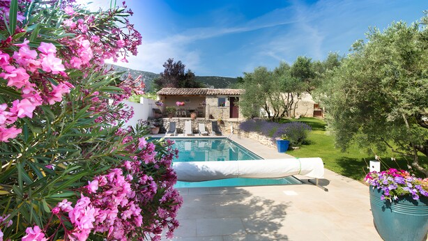 A pool area with a clear view of a building in the background, surrounded by greenery. - Maison l'Oustalette de Mau-bé with Pool in the Luberon (Maubec)