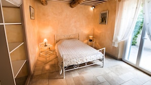 A bedroom with a bed, bedside lamps, a window with curtains, and a wooden ceiling. - Maison l'Oustalette de Mau-bé with Pool in the Luberon (Maubec)