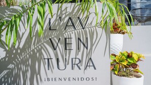 Un letrero con el texto 'L'AV VEN TURA' y '¡BIENVENIDOS!' dando la bienvenida a los huéspedes.