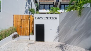 Un edificio moderno con un letrero que dice "L'AVENTURA" en la entrada.