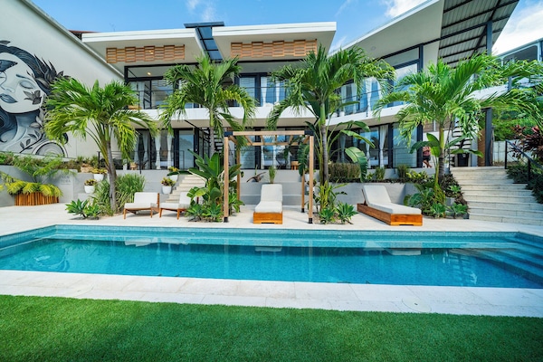 Una piscina al aire libre, sombrillas, tumbonas