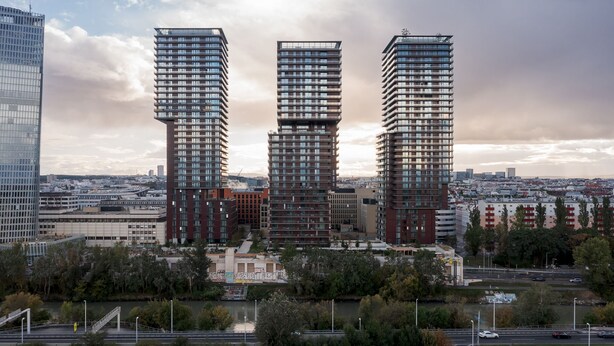 Three high-rise buildings with a modern architectural design, featuring multiple balconies and a mix of glass and brick facades. - Penthouse Apartment with Rooftop Pool (Vienna)