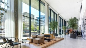 A spacious lobby with large windows, a seating area with sofas and chairs, and a coffee table. - Penthouse Apartment with Rooftop Pool (Vienna)