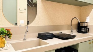 Eine moderne Küche mit Spüle, Kaffeemaschine und einem kompakten Kühlschrank.