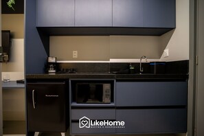 A modern kitchen with a built-in microwave, coffee maker, and a sink.