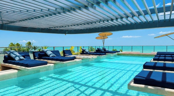 A poolside area with lounge chairs and a view of the ocean. - Setai Aquamaris - LikeHome Hospedagens (João Pessoa)