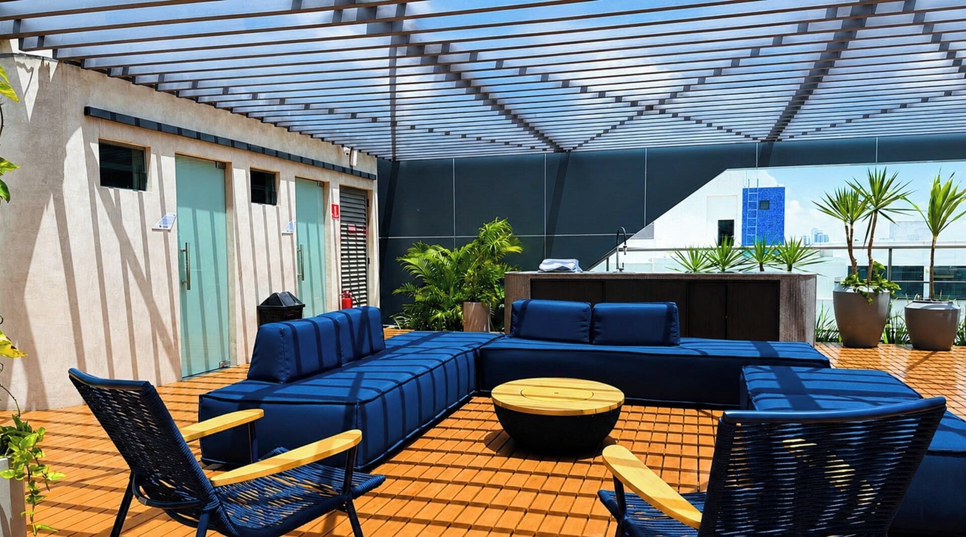 Un área de estar al aire libre con un sofá modular, sillas y una mesa redonda.