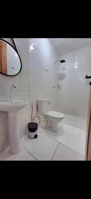 Een douche, handdoeken, zeep, toiletpapier