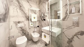 A modern bathroom with a bidet, a glass-enclosed shower, and a marble backsplash. - Chessa's Rooms (Rome)
