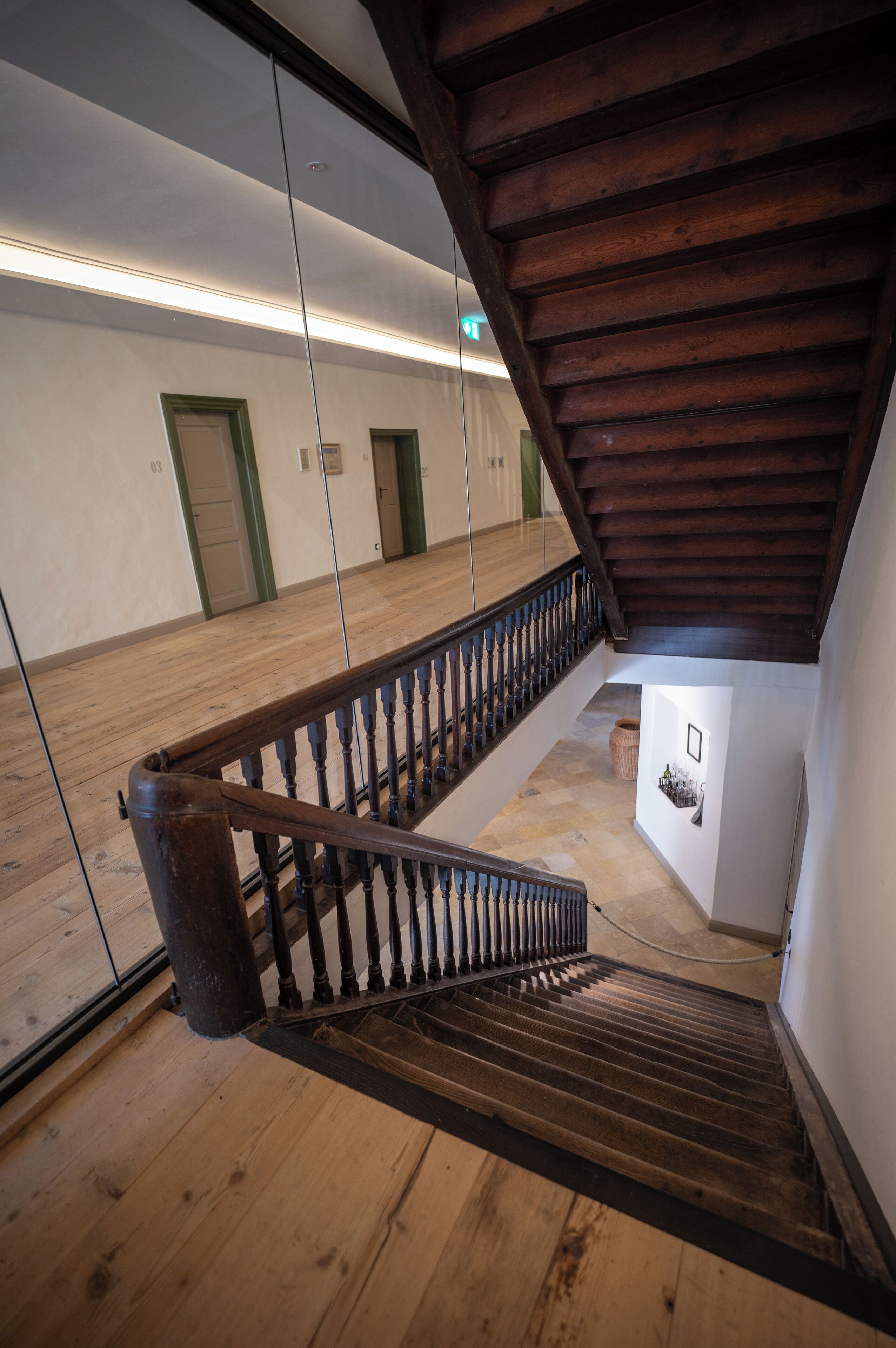 Eine Holztreppe mit Geländer, die zu einer Zwischenebene führt.