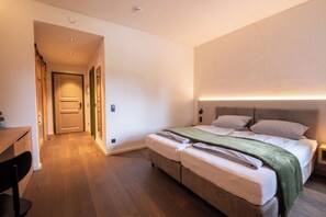 A modern bedroom with a bed, bedside tables, and a desk.