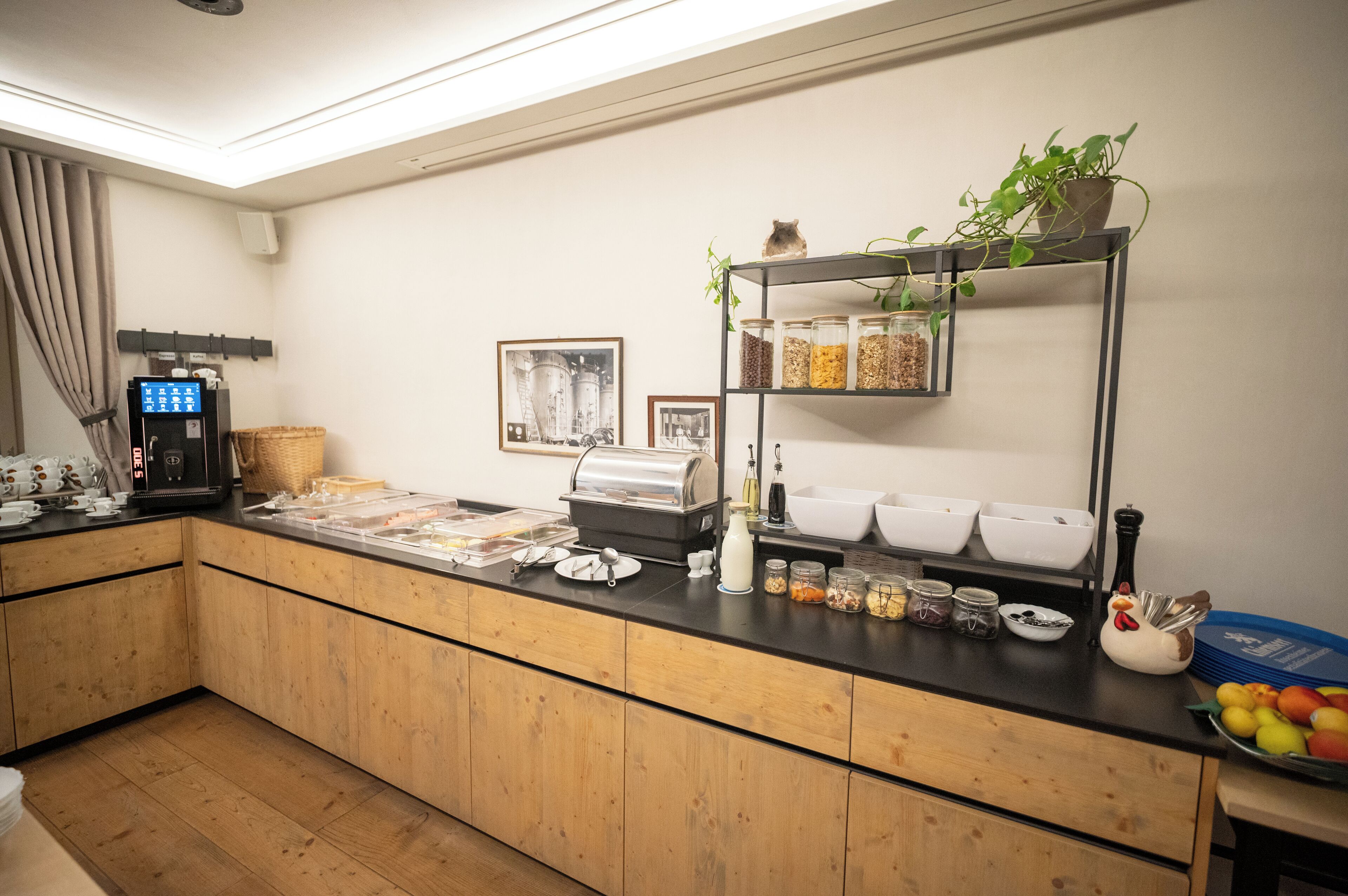 Ein Buffet mit Selbstbedienungsbereich, einer Kaffeemaschine und verschiedenen Speisebehältern.
