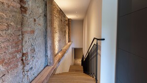 A staircase with exposed brick walls and wooden steps, leading to a modern interior space. - Landhotel Alte Zollstation (Pittenhart)