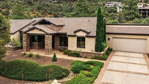 A two-story house with a stone facade, a tiled roof, and a well-maintained garden. - Serene Luxe Prescott Pines Hideaway, Games + Epic Views, Sleep 16+, Fun For All! (Prescott)