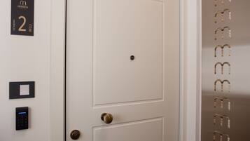 Une porte de chambre d’hôtel avec un panneau indiquant le numéro de la chambre, un clavier numérique et un bouton de sonnette.