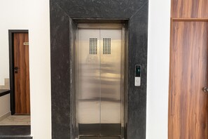 An elevator with a control panel and a privacy sign on the door. - Hotel Veronica (Indore)