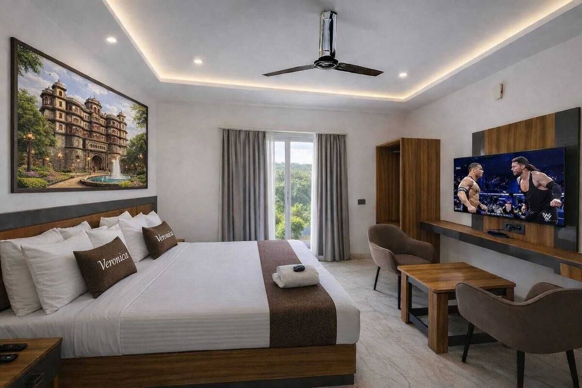 Une chambre d’hôtel avec un grand lit, une télévision, un bureau et une chaise.