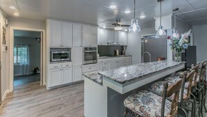 A modern kitchen with white cabinets, a marble countertop, and pendant lighting. - Marlandwood Estate - Spacious 5-bedroom house in Temple with outdoor space (Temple)